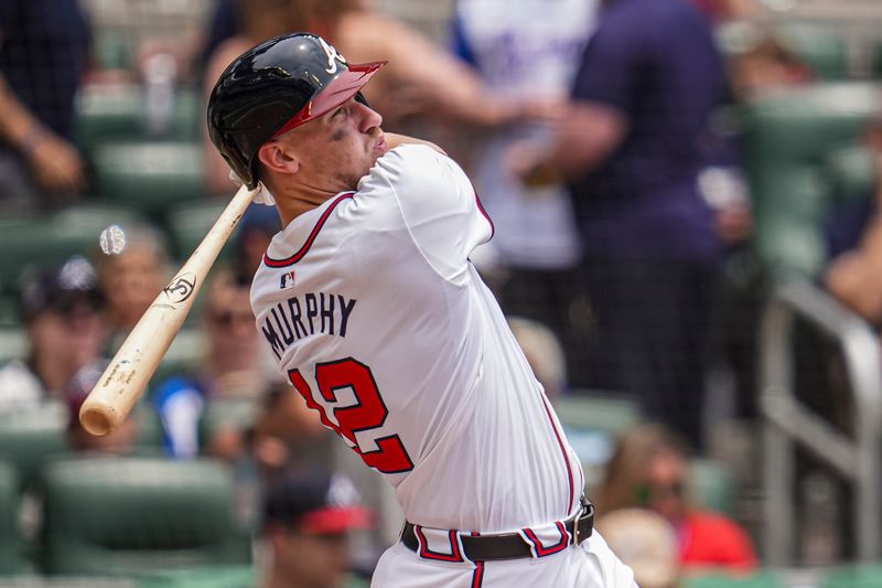 Jun 19, 2024; Cumberland, Georgia, USA; Atlanta Braves catcher Sean Murphy (12) hits a two run home run against the Detroit Tigers during the third inning at Truist Park. Mandatory Credit: Dale Zanine-USA TODAY Sports