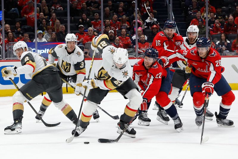 Oct 15, 2024; Washington, District of Columbia, USA; Vegas Golden Knights center Brett Howden (21) clears the puck from Washington Capitals right wing Brandon Duhaime (22) in the first period at Capital One Arena. Mandatory Credit: Geoff Burke-Imagn Images
