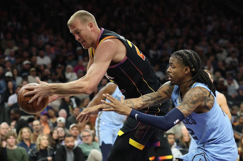 PHOENIX, ARIZONA - FEBRUARY 11: Mason Plumlee #22 of the Phoenix Suns handles the ball against Ja Morant #12 of the Memphis Grizzlies during the first half of the NBA game at Footprint Center on February 11, 2025 in Phoenix, Arizona.  NOTE TO USER: User expressly acknowledges and agrees that, by downloading and or using this photograph, User is consenting to the terms and conditions of the Getty Images License Agreement.  (Photo by Christian Petersen/Getty Images)