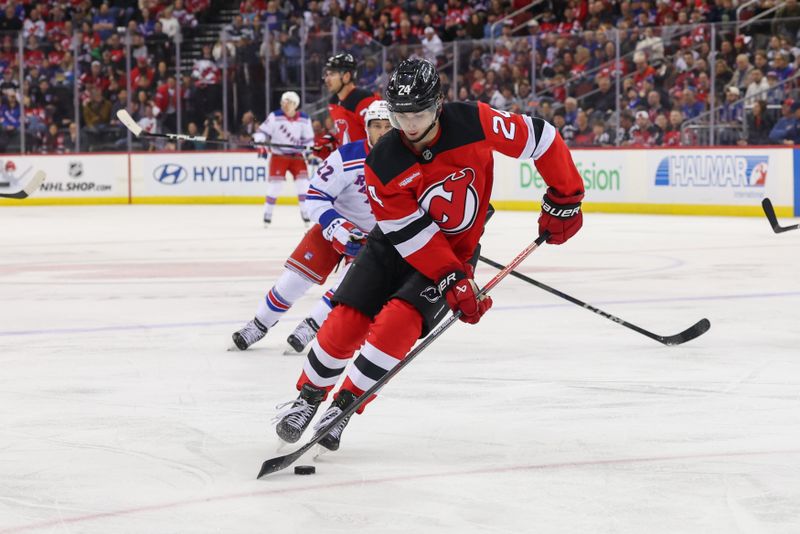 Apr 5, 2025; Newark, New Jersey, USA; New Jersey Devils defenseman Seamus Casey (24) skates with the puck against the New York Rangers during the first period at Prudential Center. Mandatory Credit: Ed Mulholland-Imagn Images