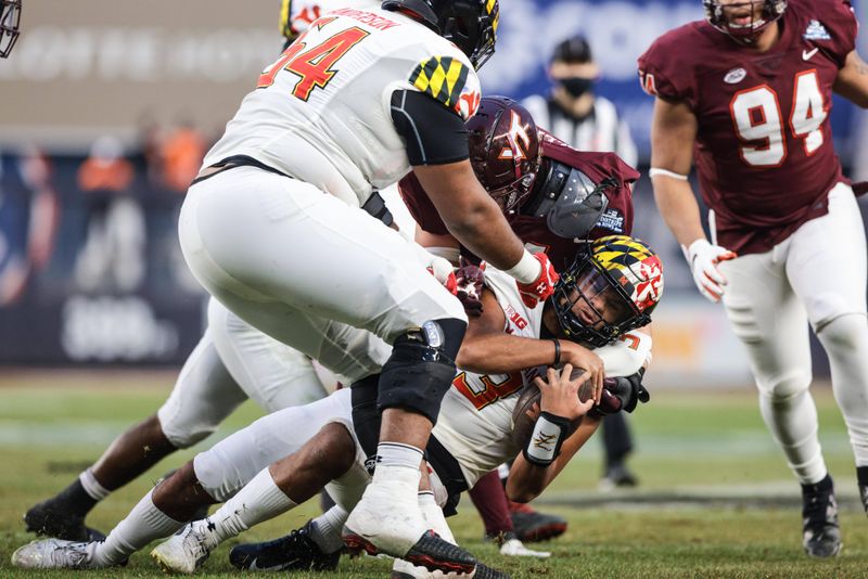 Dec 29, 2021; New York, NY, USA; Maryland Terrapins quarterback Taulia Tagovailoa (3) is tackled by Virginia Tech Hokies linebacker Dax Hollifield (4) during the second half of the 2021 Pinstripe Bowl at Yankee Stadium. Mandatory Credit: Vincent Carchietta-USA TODAY Sports