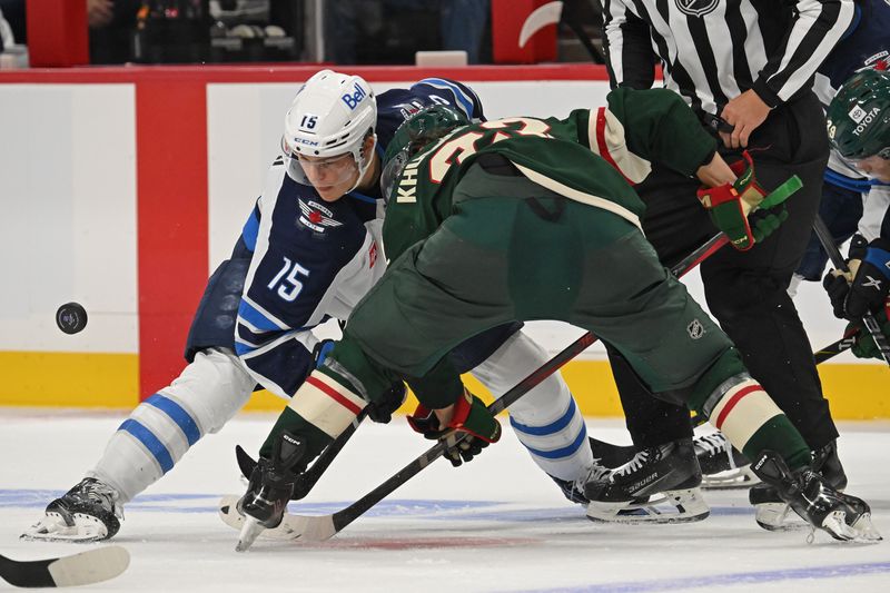 Sep 27, 2024; Saint Paul, Minnesota, USA;  Winnipeg Jets forward Rasmus Kupari (15) and Minnesota Wild forward Marat Khusnutdinov (22) face-off during the third period at Xcel Energy Center. Mandatory Credit: Nick Wosika-Imagn Images

