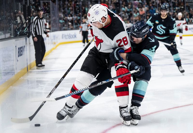 Dec 7, 2023; Seattle, Washington, USA; New Jersey Devils forward Timo Meier (28) and Seattle Kraken defenseman Brian Dumoulin (8) battle for the puck during the third period at Climate Pledge Arena. Mandatory Credit: Stephen Brashear-USA TODAY Sports