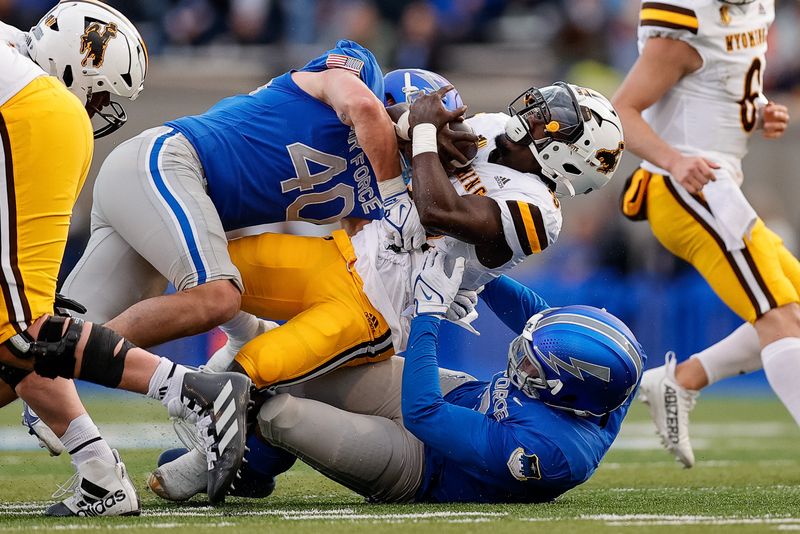 Oct 14, 2023; Colorado Springs, Colorado, USA; Wyoming Cowboys running back Jamari Ferrell (32) is tackled by Air Force Falcons linebacker Alec Mock (40) and linebacker PJ Ramsey (13) in the second quarter at Falcon Stadium. Mandatory Credit: Isaiah J. Downing-USA TODAY Sports