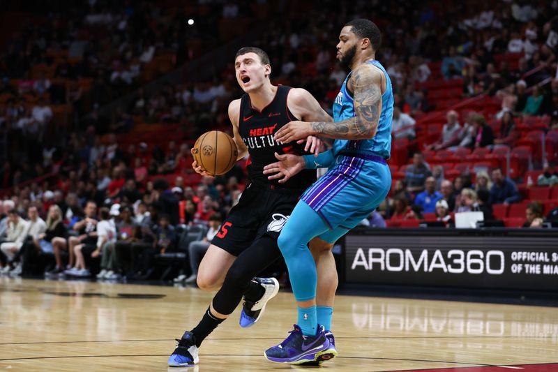 MIAMI, FLORIDA - JANUARY 14: Nikola Jovic #5 of the Miami Heat drives against Miles Bridges #0 of the Charlotte Hornets during the first quarter at Kaseya Center on January 14, 2024 in Miami, Florida. NOTE TO USER: User expressly acknowledges and agrees that, by downloading and or using this photograph, User is consenting to the terms and conditions of the Getty Images License Agreement.  (Photo by Megan Briggs/Getty Images)