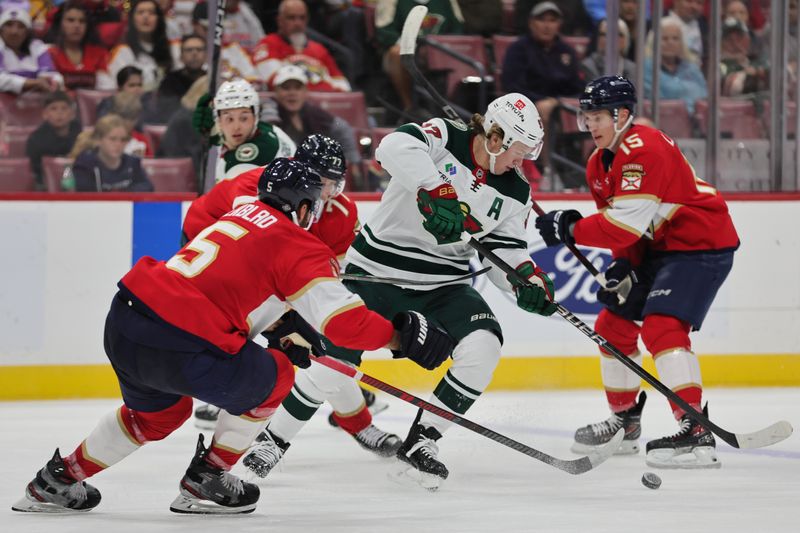 Oct 22, 2024; Sunrise, Florida, USA; Minnesota Wild left wing Kirill Kaprizov (97) moves the puck past Florida Panthers defenseman Niko Mikkola (77) during the first period at Amerant Bank Arena. Mandatory Credit: Sam Navarro-Imagn Images