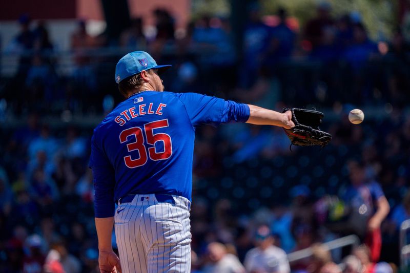 Mar 22, 2024; Mesa, Arizona, USA; Chicago Cubs starting pitcher Justin Steele (35) reaches out to catch a baseball in the first inning during a spring training game against the San Francisco Giants at Sloan Park. Mandatory Credit: Allan Henry-USA TODAY Sports