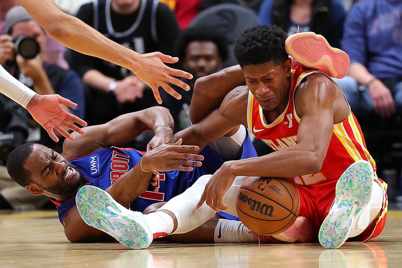 ATLANTA, GEORGIA - DECEMBER 18:  De'Andre Hunter #12 of the Atlanta Hawks draws a foul as he battles for a loose ball against Alec Burks #14 of the Detroit Pistons during the fourth quarter at State Farm Arena on December 18, 2023 in Atlanta, Georgia.  NOTE TO USER: User expressly acknowledges and agrees that, by downloading and/or using this photograph, user is consenting to the terms and conditions of the Getty Images License Agreement.  (Photo by Kevin C. Cox/Getty Images)