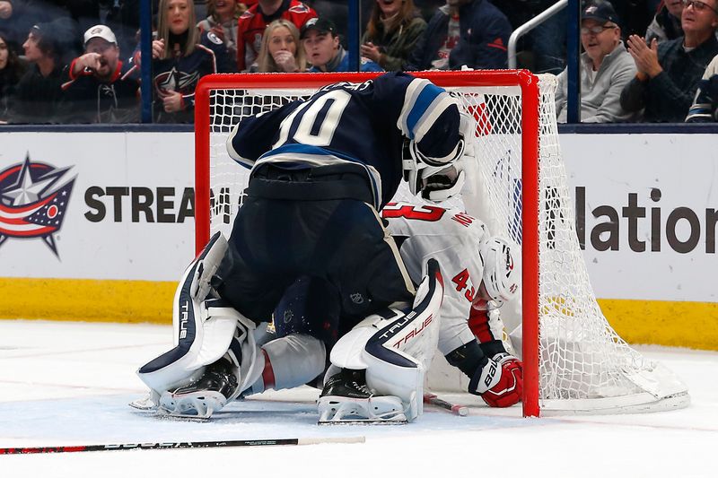 Dec 21, 2023; Columbus, Ohio, USA; Columbus Blue Jackets goalie Elvis Merzlikins (90) and Washington Capitals right wing Tom Wilson (43) tangle inside the net during overtime at Nationwide Arena. Mandatory Credit: Russell LaBounty-USA TODAY Sports