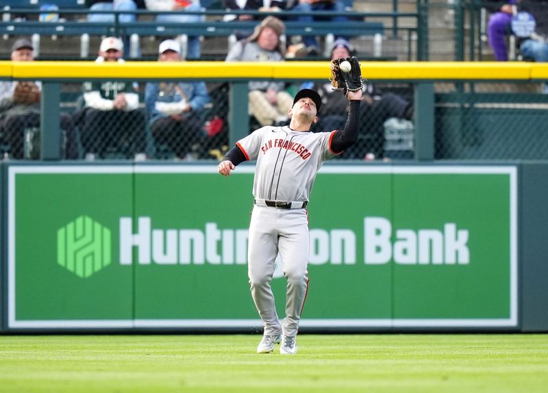 May 8, 2024; Denver, Colorado, USA; San Francisco Giants outfielder Michael Conforto (8) fields the ball in the first inning against the Colorado Rockies at Coors Field. Mandatory Credit: Ron Chenoy-USA TODAY Sports