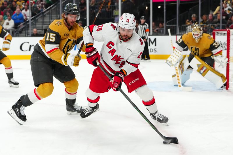 Nov 11, 2024; Las Vegas, Nevada, USA; Carolina Hurricanes left wing William Carrier (28) controls the puck in front of Vegas Golden Knights defenseman Noah Hanifin (15) during the first period at T-Mobile Arena. Mandatory Credit: Stephen R. Sylvanie-Imagn Images