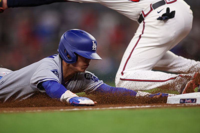 May 4, 2025; Atlanta, Georgia, USA; Los Angeles Dodgers second baseman Hyeseong Kim (6) slides into third base against the Atlanta Braves in the ninth inning at Truist Park. Mandatory Credit: Brett Davis-Imagn Images