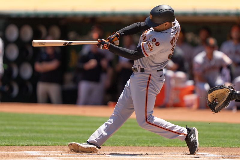 Aug 6, 2023; Oakland, California, USA;  San Francisco Giants first baseman LaMonte Wade Jr. (31) hits a single during the first inning against the Oakland Athletics at Oakland-Alameda County Coliseum. Mandatory Credit: Stan Szeto-USA TODAY Sports