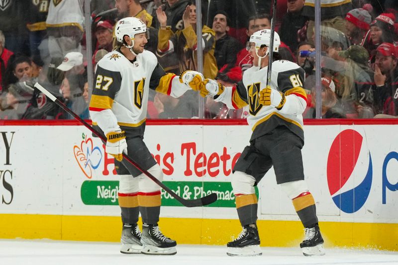 Mar 11, 2023; Raleigh, North Carolina, USA;  Vegas Golden Knights right wing Jonathan Marchessault (81) is congratulated by defenseman Shea Theodore (27) after his goal against the Carolina Hurricanes during the first period at PNC Arena. Mandatory Credit: James Guillory-USA TODAY Sports