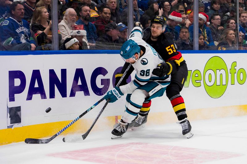 Dec 23, 2023; Vancouver, British Columbia, CAN; Vancouver Canucks forward Teddy Blueger (53) checks San Jose Sharks defenseman Mario Ferraro (38) in the third period at Rogers Arena. Canucks won 7-4. Mandatory Credit: Bob Frid-USA TODAY Sports