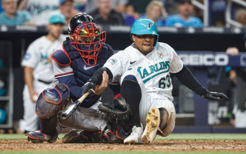 Sep 15, 2023; Miami, Florida, USA; Miami Marlins shortstop Xavier Edwards (63) falls on Atlanta Braves catcher Travis d'Arnaud (16) after being hit by a pitch during the seventh inning at loanDepot Park. Mandatory Credit: Rhona Wise-USA TODAY Sports