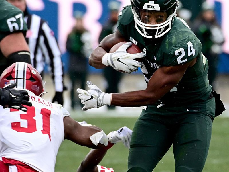 Nov 19, 2022; East Lansing, Michigan, USA;  Michigan State Spartans running back Elijah Collins (24) runs through a hole in the Indiana Hoosiers line in the fourth quarter at Spartan Stadium. Mandatory Credit: Dale Young-USA TODAY Sports