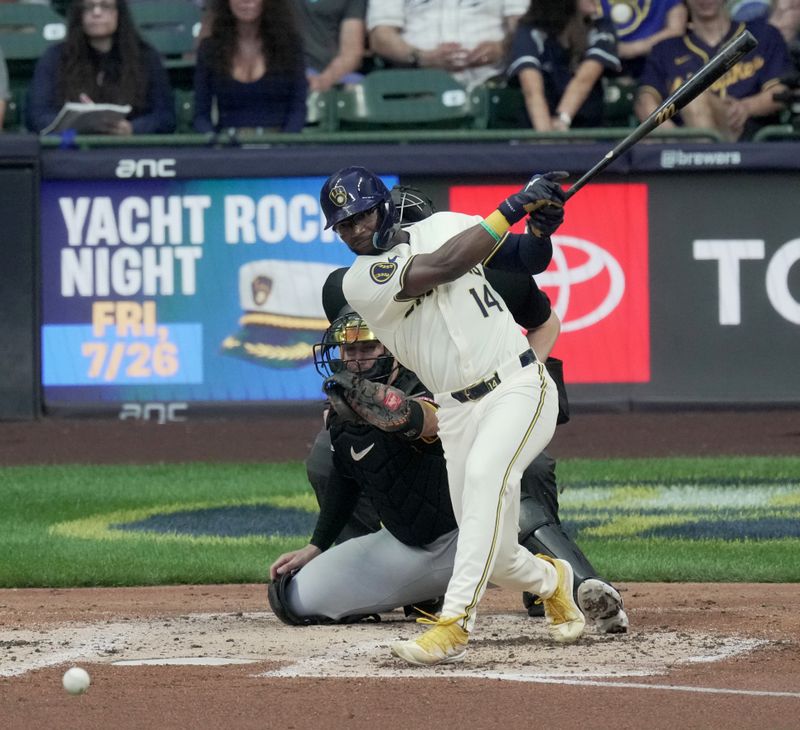 Jul 10, 2024; Milwaukee, Wisconsin, USA; Milwaukee Brewers second baseman Andruw Monasterio (14) hits a single during the fourth inning against the Pittsburgh Pirates at American Family Field in Milwaukee, Wisconsin.  Mandatory Credit: Mark Hoffman-USA TODAY Sports