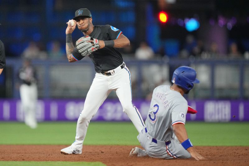 May 31, 2024; Miami, Florida, USA;  Miami Marlins shortstop Tim Anderson (7) turns a double-play against the Texas Rangers in the second inning at loanDepot Park. Mandatory Credit: Jim Rassol-USA TODAY Sports