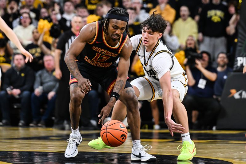 Jan 28, 2026; Iowa City, Iowa, USA; Southern California Trojans guard Kam Woods (13) and Iowa Hawkeyes guard Isaia Howard (23) battle for the ball during the second half at Carver-Hawkeye Arena. Mandatory Credit: Jeffrey Becker-Imagn Images