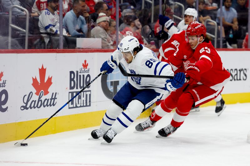 Oct 3, 2024; Detroit, Michigan, USA;  Toronto Maple Leafs left wing Nicholas Robertson (89) skates with the puck defended by Detroit Red Wings defenseman Moritz Seider (53) in the first period at Little Caesars Arena. Mandatory Credit: Rick Osentoski-Imagn Images