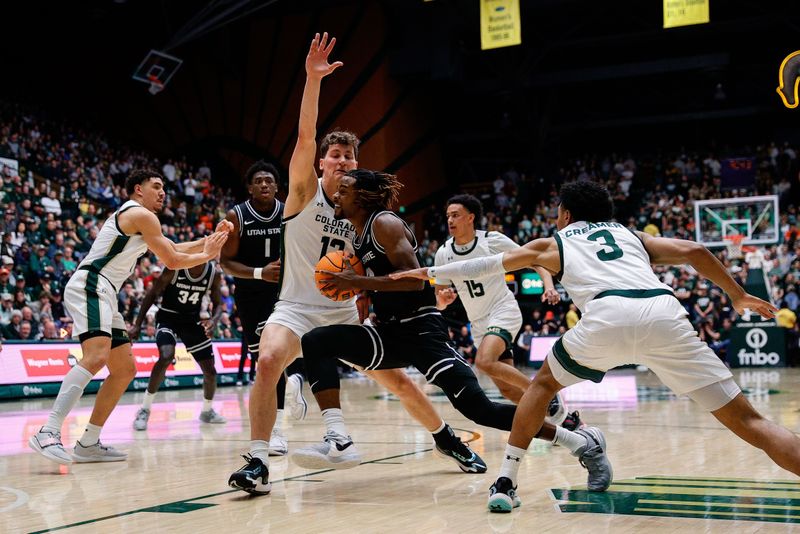 Feb 17, 2024; Fort Collins, Colorado, USA; Utah State Aggies guard Josh Uduje (14) drives to the basket against Colorado State Rams forward Patrick Cartier (12) and guard Josiah Strong (3) in the first half at Moby Arena. Mandatory Credit: Isaiah J. Downing-USA TODAY Sports