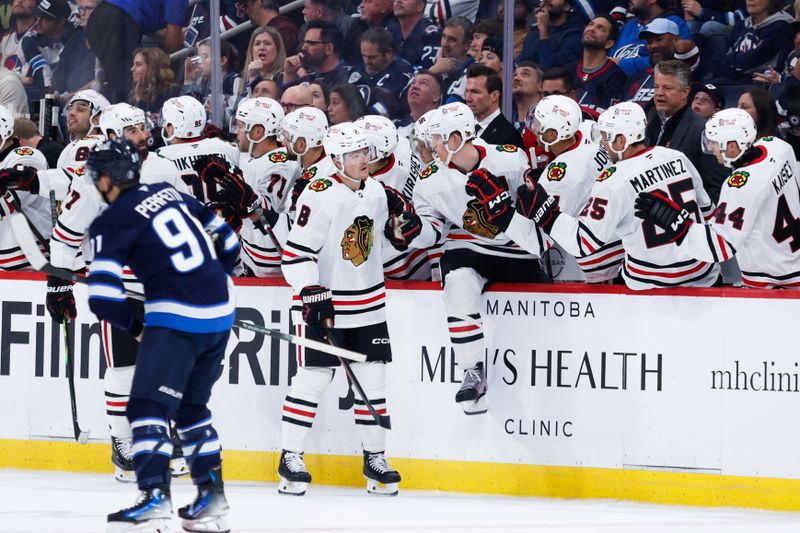 Oct 11, 2024; Winnipeg, Manitoba, CAN;  Chicago Blackhawks forward Ryan Donato (8) is congratulated by his team mates on his goal against the Winnipeg Jets during the second period at Canada Life Centre. Mandatory Credit: Terrence Lee-Imagn Images