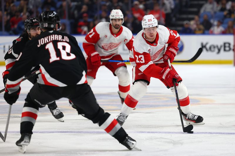 Oct 26, 2024; Buffalo, New York, USA;  Detroit Red Wings left wing Lucas Raymond (23) skates up ice with the puck during the third period against the Buffalo Sabres at KeyBank Center. Mandatory Credit: Timothy T. Ludwig-Imagn Images