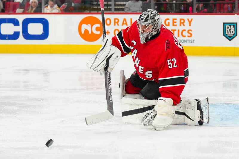 Dec 18, 2022; Raleigh, North Carolina, USA;  Carolina Hurricanes goaltender Pyotr Kochetkov (52) watches the shot against the Pittsburgh Penguins during the second period at PNC Arena. Mandatory Credit: James Guillory-USA TODAY Sports