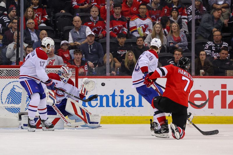 Nov 7, 2024; Newark, New Jersey, USA; Montreal Canadiens goaltender Sam Montembeault (35) makes a save on New Jersey Devils defenseman Dougie Hamilton (7) during the third period at Prudential Center. Mandatory Credit: Ed Mulholland-Imagn Images