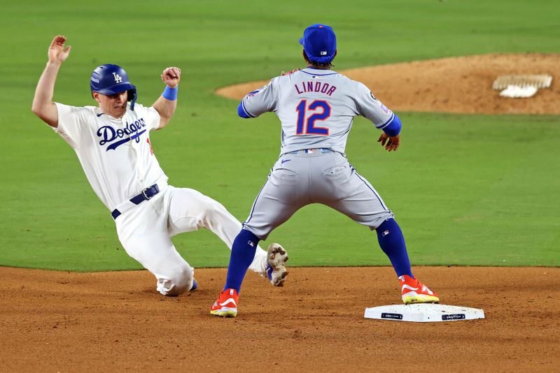 Oct 20, 2024; Los Angeles, California, USA; Los Angeles Dodgers catcher Will Smith (16) reaches second base after a late throw to New York Mets shortstop Francisco Lindor (12) during the sixth inning during game six of the NLCS for the 2024 MLB playoffs at Dodger Stadium. Mandatory Credit: Jason Parkhurst-Imagn Images