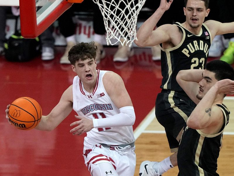 Feb 4, 2024; Madison, Wisconsin, USA; Wisconsin guard Max Klesmit (11) passes around Purdue center Zach Edey (15) during the first half at Kohl Center. Mandatory Credit: Kayla Wolf-USA TODAY Sports