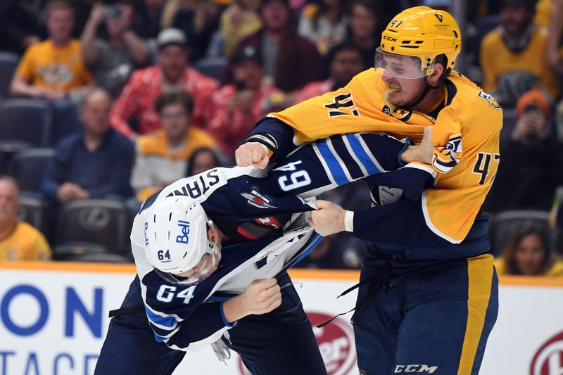 Apr 9, 2024; Nashville, Tennessee, USA; Nashville Predators right wing Michael McCarron (47) hits Winnipeg Jets defenseman Logan Stanley (64) during a fight in the third period at Bridgestone Arena. Mandatory Credit: Christopher Hanewinckel-USA TODAY Sports