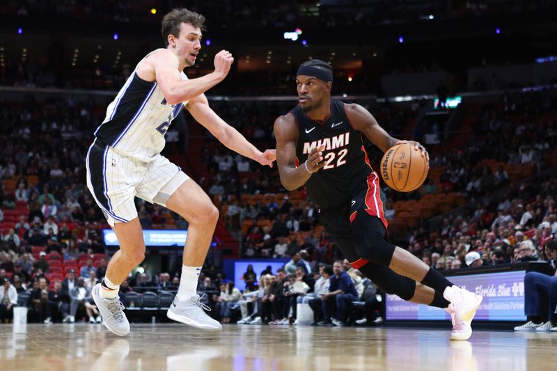 MIAMI, FLORIDA - FEBRUARY 06: Jimmy Butler #22 of the Miami Heat drives against Franz Wagner #22 of the Orlando Magic during the third quarter at Kaseya Center on February 06, 2024 in Miami, Florida. NOTE TO USER: User expressly acknowledges and agrees that, by downloading and or using this photograph, User is consenting to the terms and conditions of the Getty Images License Agreement. (Photo by Megan Briggs/Getty Images)