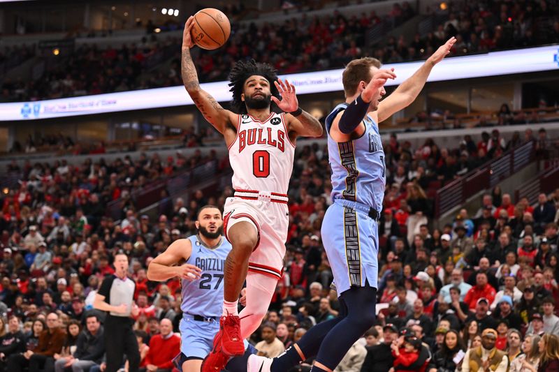 CHICAGO, ILLINOIS - APRIL 02:  Coby White #0 of the Chicago Bulls goes to the basket past Luke Kennard #10 of the Memphis Grizzlies for a layup in the first half on April 02, 2023 at United Center in Chicago, Illinois.   NOTE TO USER: User expressly acknowledges and agrees that, by downloading and or using this photograph, User is consenting to the terms and conditions of the Getty Images License Agreement.  (Photo by Jamie Sabau/Getty Images)