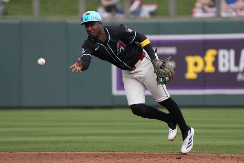Mar 3, 2025; Salt River Pima-Maricopa, Arizona, USA; Arizona Diamondbacks shortstop Geraldo Perdomo (2) flips the ball for an out against the Chicago Cubs in the second inning at Salt River Fields at Talking Stick. Mandatory Credit: Rick Scuteri-Imagn Images
