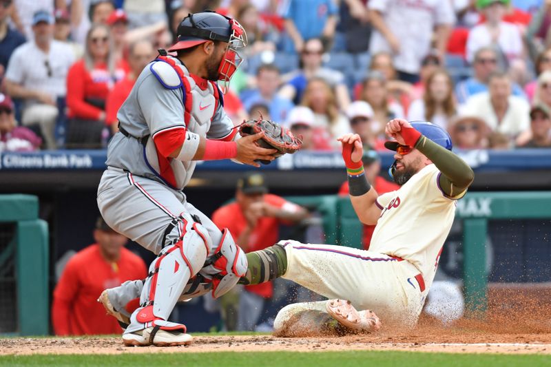 May 19, 2024; Philadelphia, Pennsylvania, USA; Philadelphia Phillies designated hitter Kyle Schwarber (12) slides safely into home ahead of tag by Washington Nationals catcher Keibert Ruiz (20) during the fifth inning at Citizens Bank Park. Mandatory Credit: Eric Hartline-USA TODAY Sports