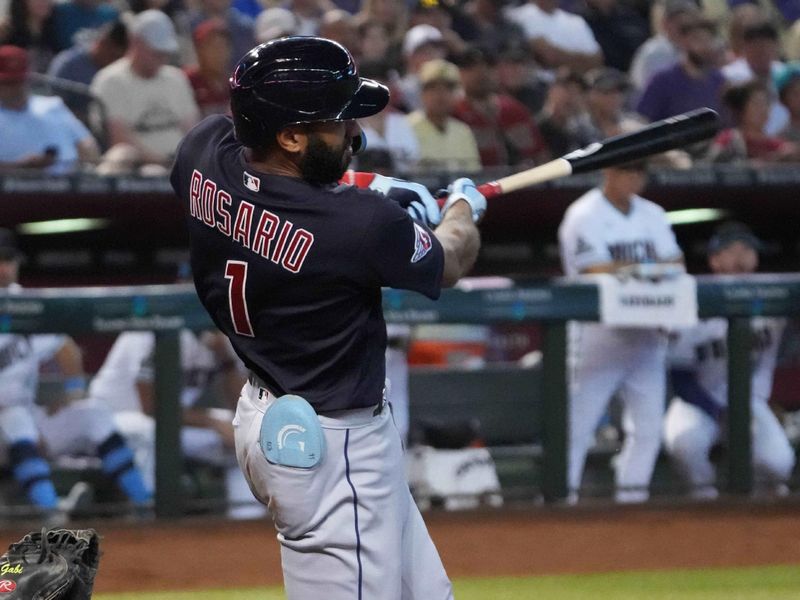 Jun 18, 2023; Phoenix, Arizona, USA; Cleveland Guardians shortstop Amed Rosario (1) hits a sacrifice fly RBI against the Arizona Diamondbacks during the second inning at Chase Field. Mandatory Credit: Joe Camporeale-USA TODAY Sports