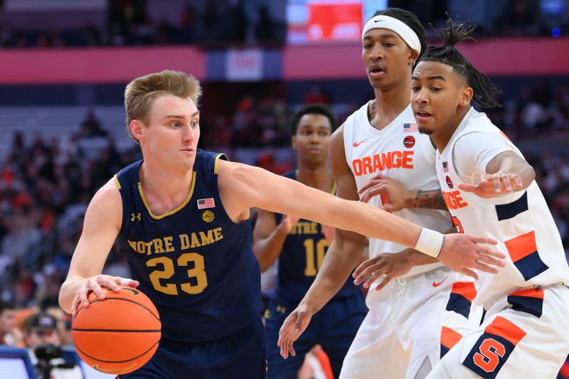 Jan 14, 2023; Syracuse, New York, USA; Notre Dame Fighting Irish guard Dane Goodwin (23) drives to the basket against the defense of Syracuse Orange forward Maliq Brown (center) and guard Judah Mintz (right) during the second half at the JMA Wireless Dome. Mandatory Credit: Rich Barnes-USA TODAY Sports