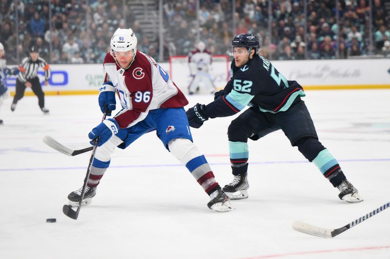 Nov 13, 2023; Seattle, Washington, USA; Colorado Avalanche right wing Mikko Rantanen (96) plays the puck while defended by Seattle Kraken left wing Tye Kartye (52) during the first period at Climate Pledge Arena. Mandatory Credit: Steven Bisig-USA TODAY Sports