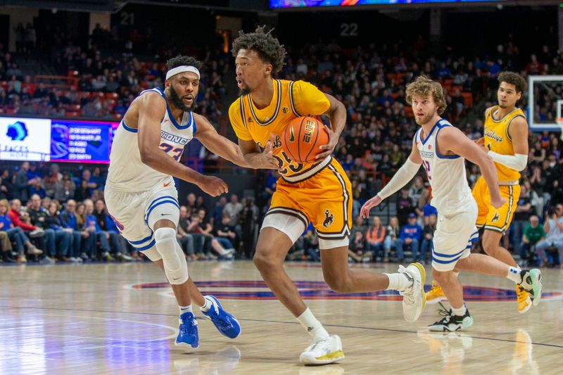 Feb 11, 2023; Boise, Idaho, USA; Wyoming Cowboys forward Jeremiah Oden (25) drives past Boise State Broncos forward Naje Smith (23) during the first half  at ExtraMile Arena. Mandatory Credit: Brian Losness-USA TODAY Sports
