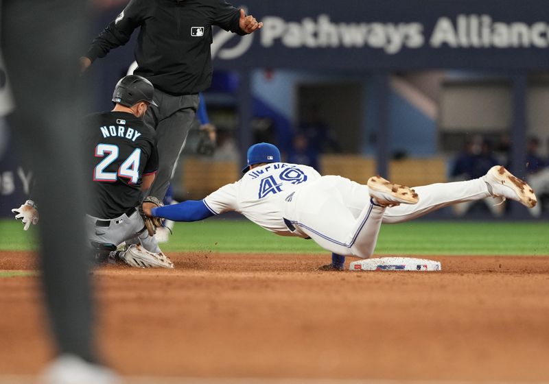 Sep 27, 2024; Toronto, Ontario, CAN; Toronto Blue Jays second baseman Leo Jimenez (49) tags out  Miami Marlins third baseman Connor Norby (24) during the fifth inning at Rogers Centre. Mandatory Credit: Nick Turchiaro-Imagn Images