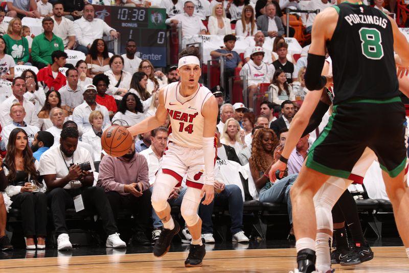 MIAMI, FL - APRIL 27: Tyler Herro #14 of the Miami Heat handles the ball against Kristaps Porzingis #8 of the Boston Celtics during the game during Round 1 Game 3 of the 2024 NBA Playoffs on April 27, 2024 at Kaseya Center in Miami, Florida. NOTE TO USER: User expressly acknowledges and agrees that, by downloading and or using this Photograph, user is consenting to the terms and conditions of the Getty Images License Agreement. Mandatory Copyright Notice: Copyright 2024 NBAE (Photo by Issac Baldizon/NBAE via Getty Images)