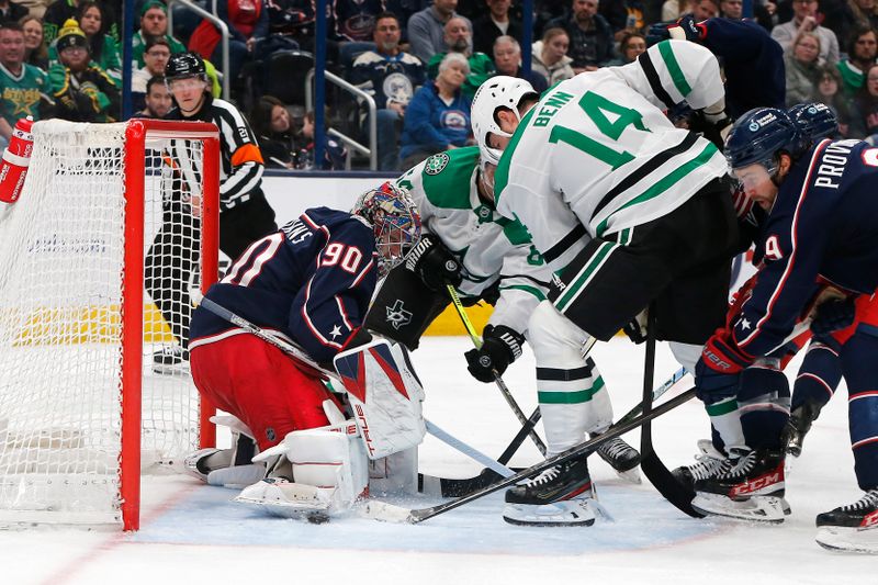 Feb 25, 2025; Columbus, Ohio, USA; Columbus Blue Jackets goalie Elvis Merzlikins (90) makes a save as Dallas Stars left wing Jamie Benn (14) looks for a rebound during the third period at Nationwide Arena. Mandatory Credit: Russell LaBounty-Imagn Images