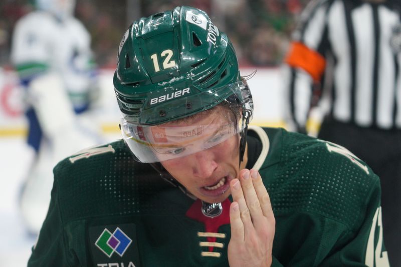 Feb 19, 2024; Saint Paul, Minnesota, USA; Minnesota Wild left winger Matt Boldy (12) gets a stick to the face against the Vancouver Canucks in the second period at Xcel Energy Center. Mandatory Credit: Matt Blewett-USA TODAY Sports