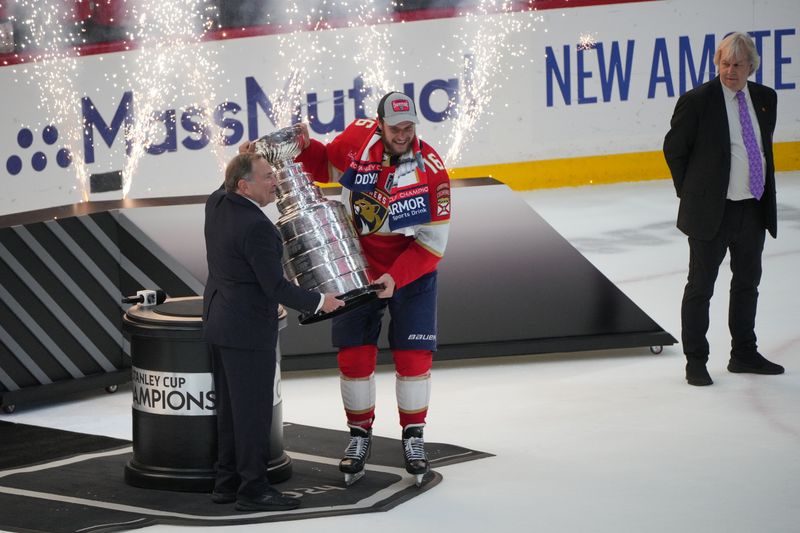 Jun 24, 2024; Sunrise, Florida, USA; The Stanley Cup is presented to Florida Panthers forward Aleksander Barkov (16) by NHL Commissioner Gary Bettman after winning against the Edmonton Oilers in game seven of the 2024 Stanley Cup Final at Amerant Bank Arena. Mandatory Credit: Jim Rassol-USA TODAY Sports
