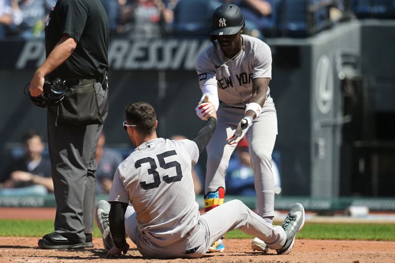 Apr 23, 2025; Cleveland, Ohio, USA; New York Yankees second baseman Jazz Chisholm Jr. (13) helps up center fielder Cody Bellinger (35) at home plate after he was thrown out by Cleveland Guardians left fielder Steven Kwan (not pictured) during the sixth inning at Progressive Field. Mandatory Credit: Ken Blaze-Imagn Images