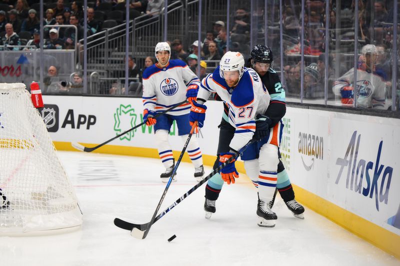 Oct 2, 2024; Seattle, Washington, USA; Edmonton Oilers defenseman Brett Kulak (27) protects the puck from Seattle Kraken right wing Oliver Bjorkstrand (22) during the third period at Climate Pledge Arena. Mandatory Credit: Steven Bisig-Imagn Images