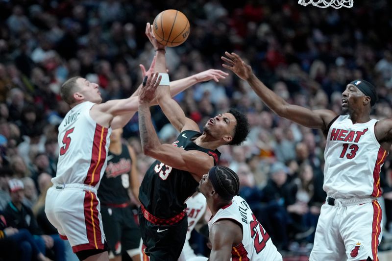 PORTLAND, OREGON - FEBRUARY 27: Toumani Camara #33 of the Portland Trail Blazers is fouled while shooting by Nikola Jovic #5 of the Miami Heat during the second half at Moda Center on February 27, 2024 in Portland, Oregon. NOTE TO USER: User expressly acknowledges and agrees that, by downloading and or using this photograph, User is consenting to the terms and conditions of the Getty Images License Agreement. (Photo by Soobum Im/Getty Images)