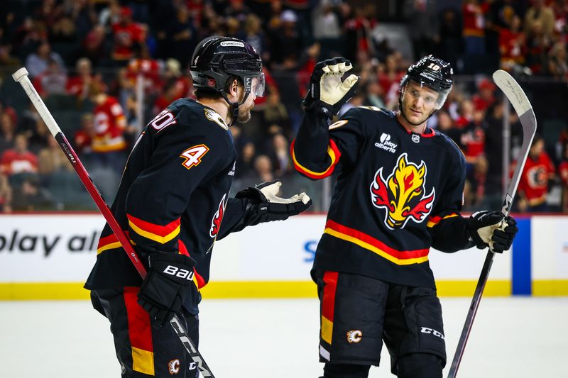 Dec 4, 2025; Calgary, Alberta, CAN; Calgary Flames defenseman Rasmus Andersson (4) celebrates his goal with left wing Jonathan Huberdeau (10) during the third period against the Minnesota Wild at Scotiabank Saddledome. Mandatory Credit: Sergei Belski-Imagn Images